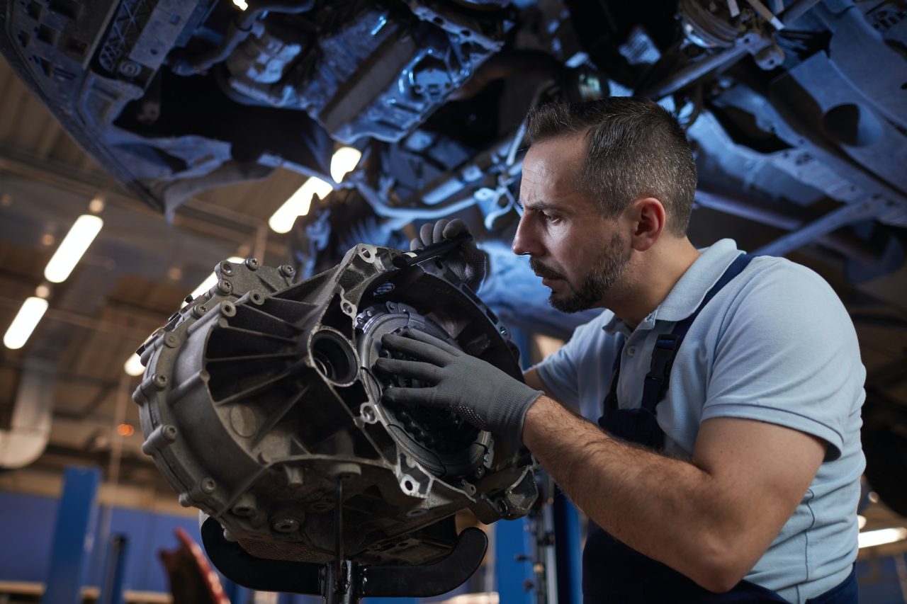 A mechanic of AK Fast Fit Tyres in Feltham doing gearbox repair for a car.