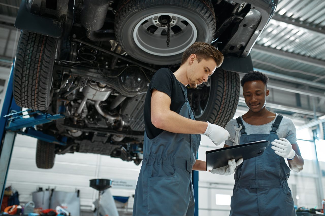 AK Fast Fit Tyres in Feltham technicians doing mot and service for a car.
