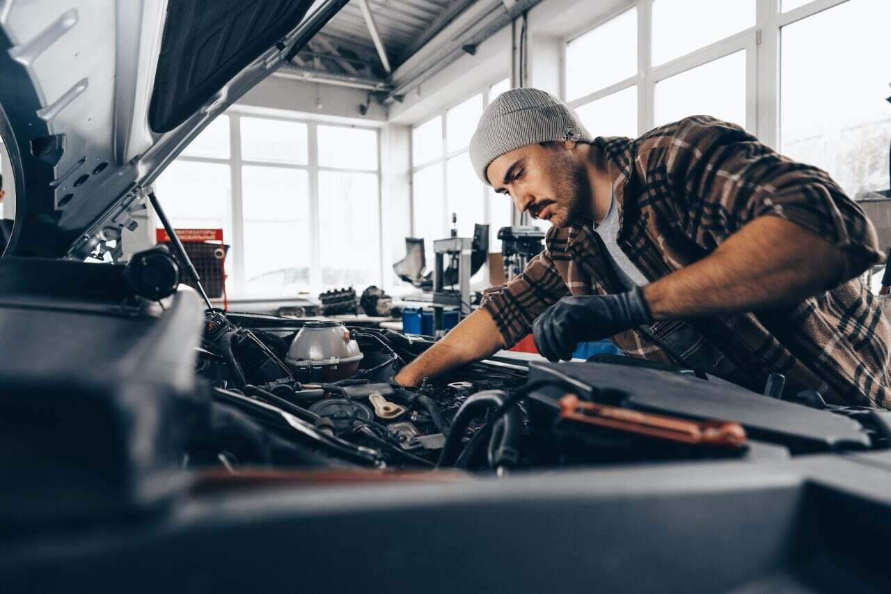 A mechanic doing mot and service for a car in feltham garage