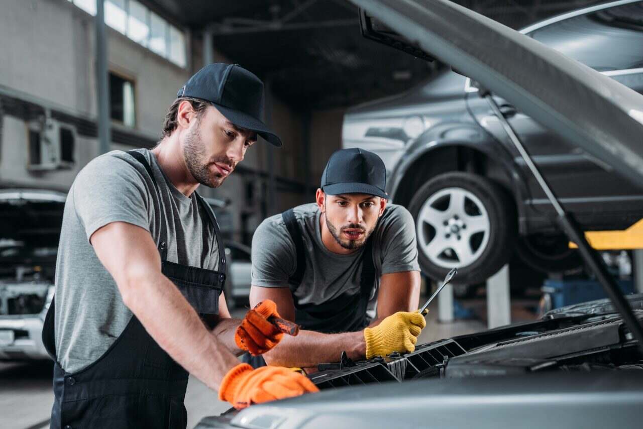 Two mechanics doing mot and service in feltham garage